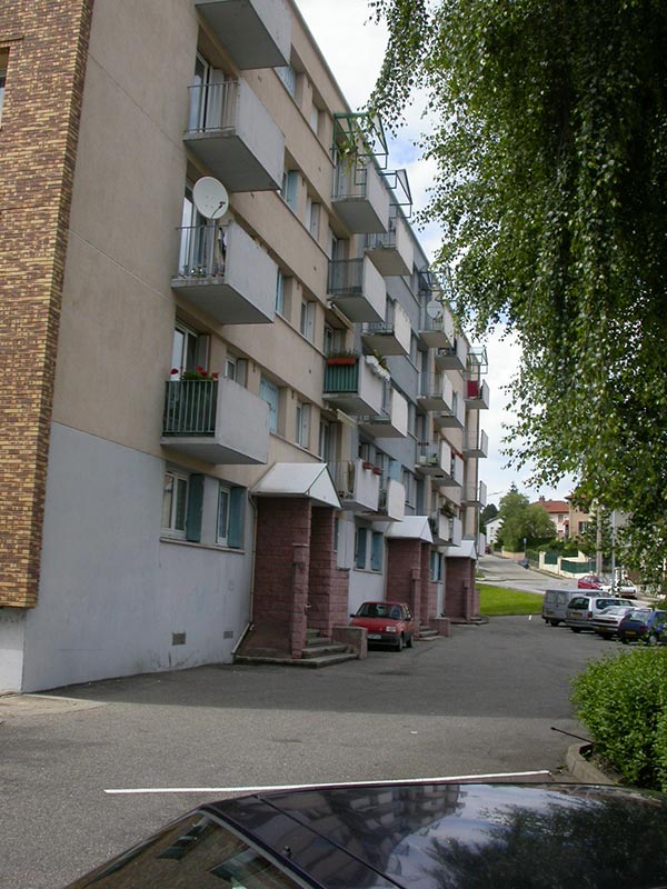 Photo de la façade depuis le parking du groupe Pasteur à La Ricamarie dans la Loire : projet de rénovation énergétique, architecturale et paysagère pour cet ensemble de logements. Projet de Pierre Scodellari, architecte Loire - Atelier Sc-a, architecte Lyon et région